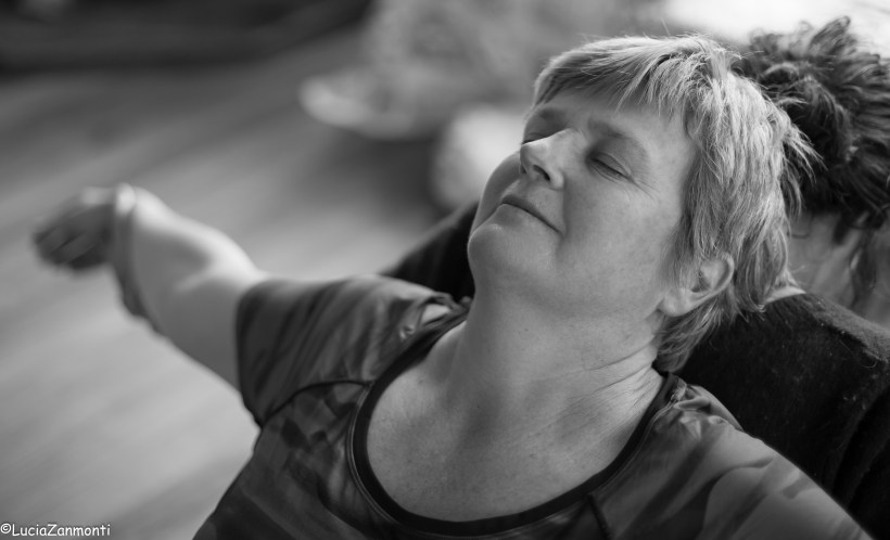 image shows woman in yoga pose stretching her back